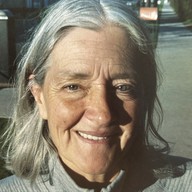 Smiling woman with silver hair on a neighbourhood sidewalk
